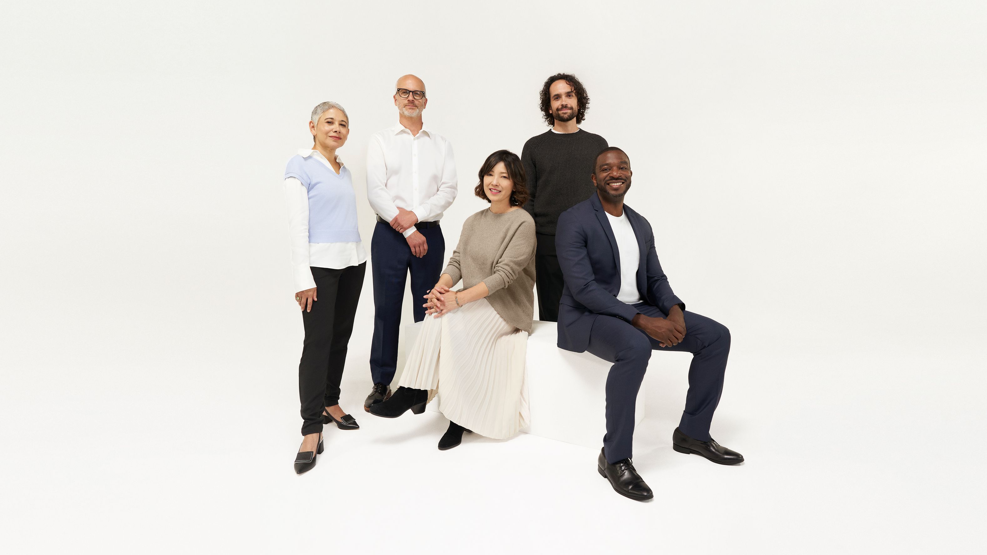 Team photo of five people on white background