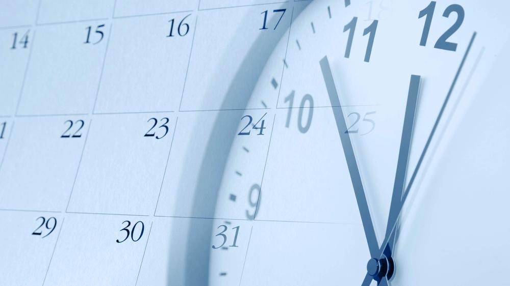 Clock ticking with calendar in background