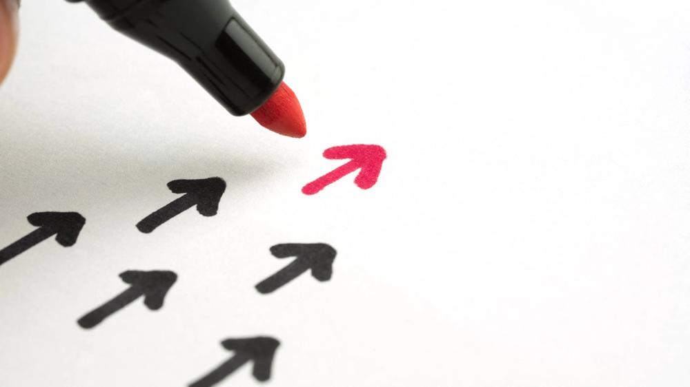 red pen drawing a leading arrow on paper