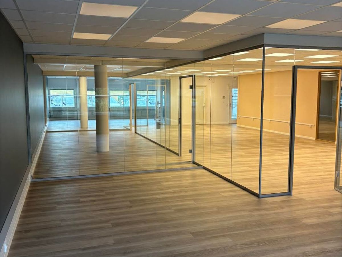 Kontorbygning med glasvægge, nye gulve og loftflader efter renovering