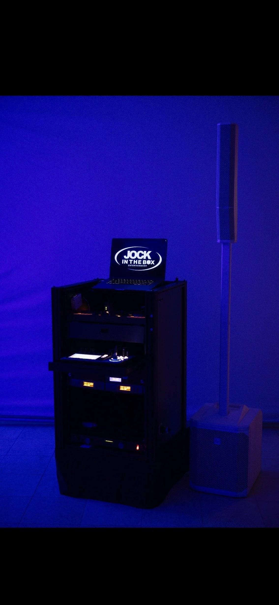 Custom Jock In The Box DJ booth lit in violet uplighting