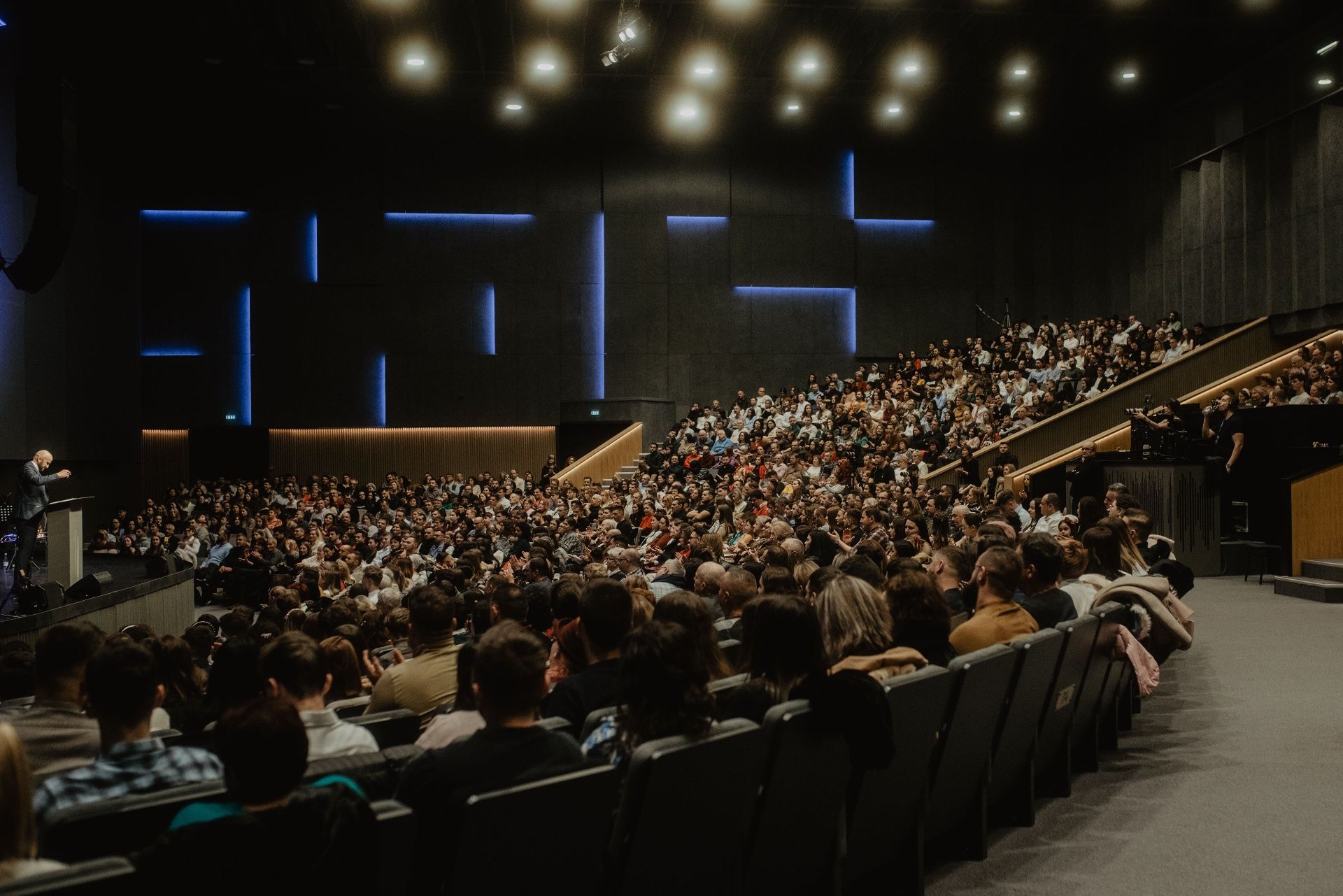 Large-scale auditorium production with a full house and stage lighting