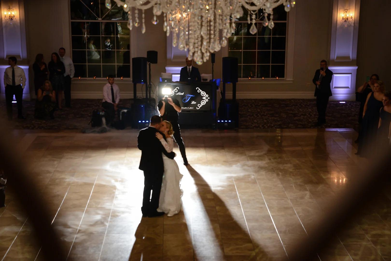 First dance under a custom spotlight and monogram projection at a Connecticut wedding