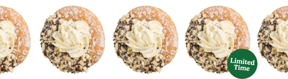Indulge in a sweet twist on this Italian classic dessert. The Cannoli Inspired Doughnut starts with an unglazed ring, half-dipped in indulgent chocolate icing and irresistible cookie crunch, dusted with a powdered sugar coating, and finally topped with a dollop of cannoli flavored buttercreme. This delicious blend of creamy, crunchy, and sweet is perfect for satisfying your sweet cravings.