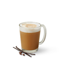 Vanilla latte with froth on top in a glass mug