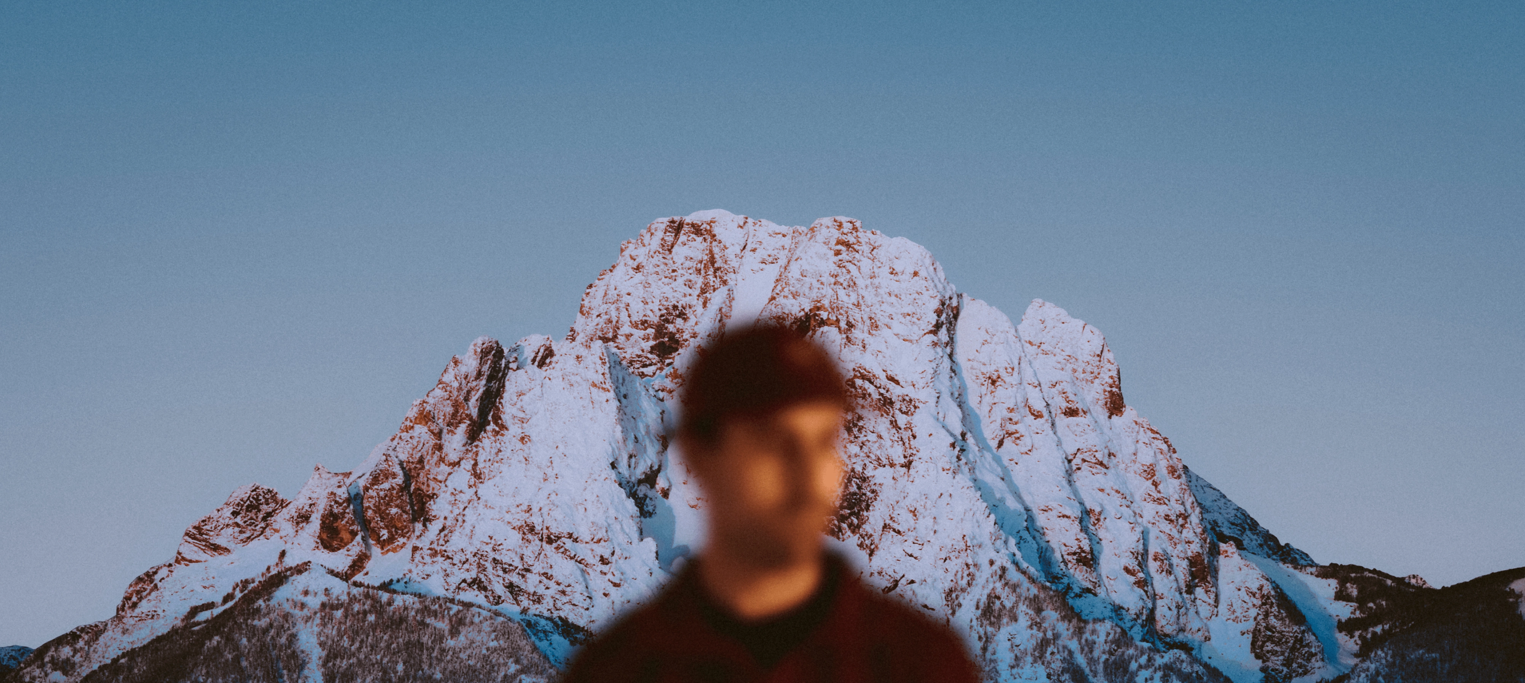 An image of a man in front of a mountain