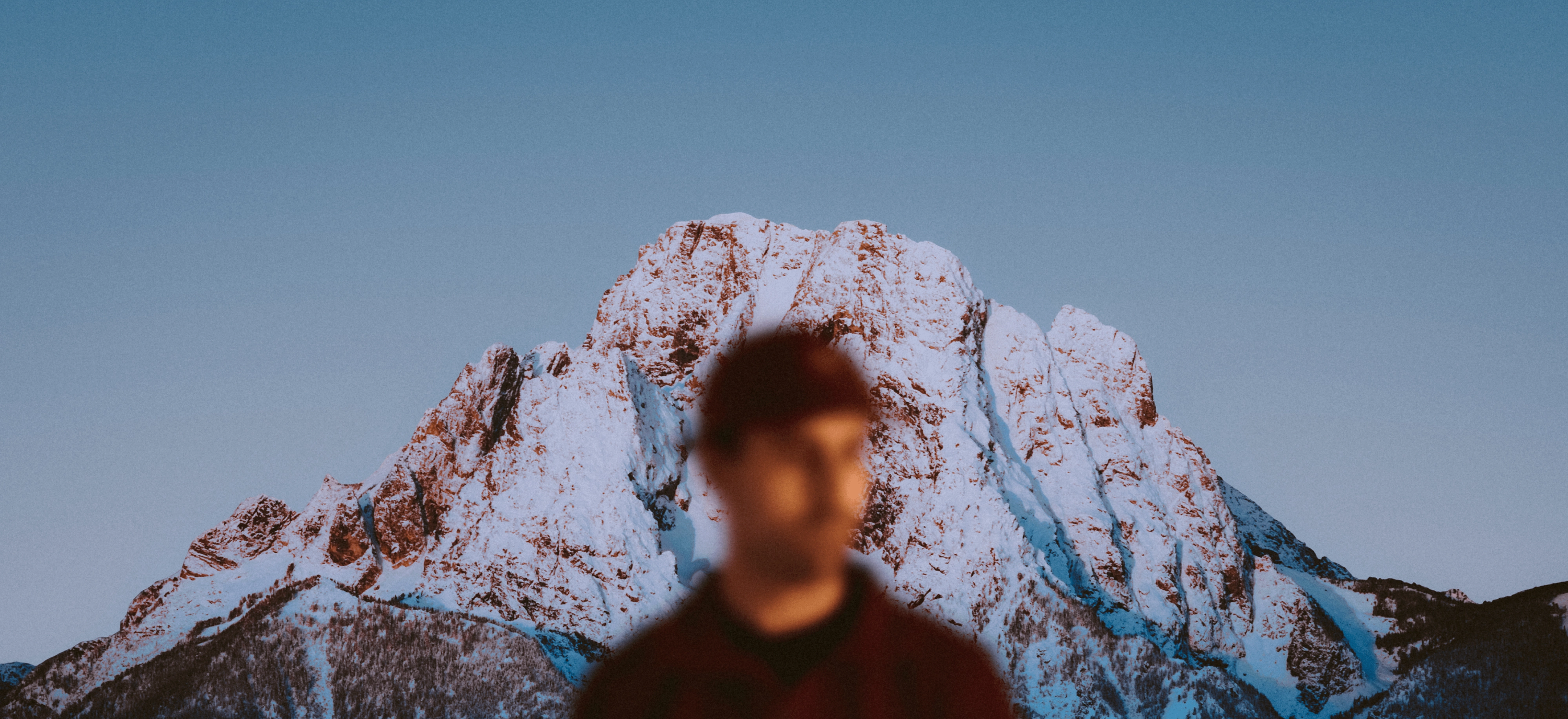 An image of a man in front of a mountain