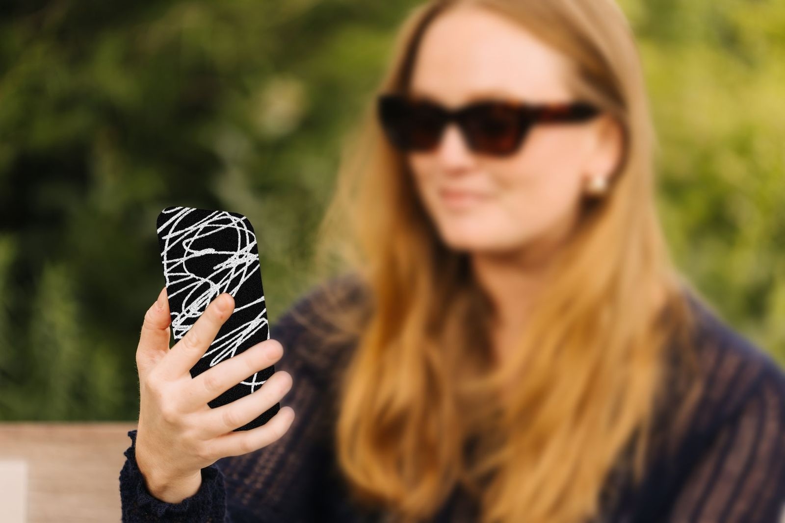An image of a person holding a phone protected by Cape