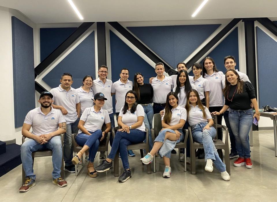 Equipo de DOMUZ posa en un salón de reuniones con camisetas de la marca