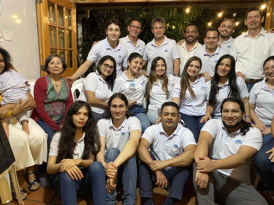 Equipo de DOMUZ con camisetas blancas de la marca, reunido en un salón durante una jornada de equipo