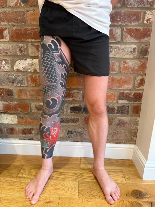 Front of the finished right leg against the brick wall, the koi swimming up the thigh