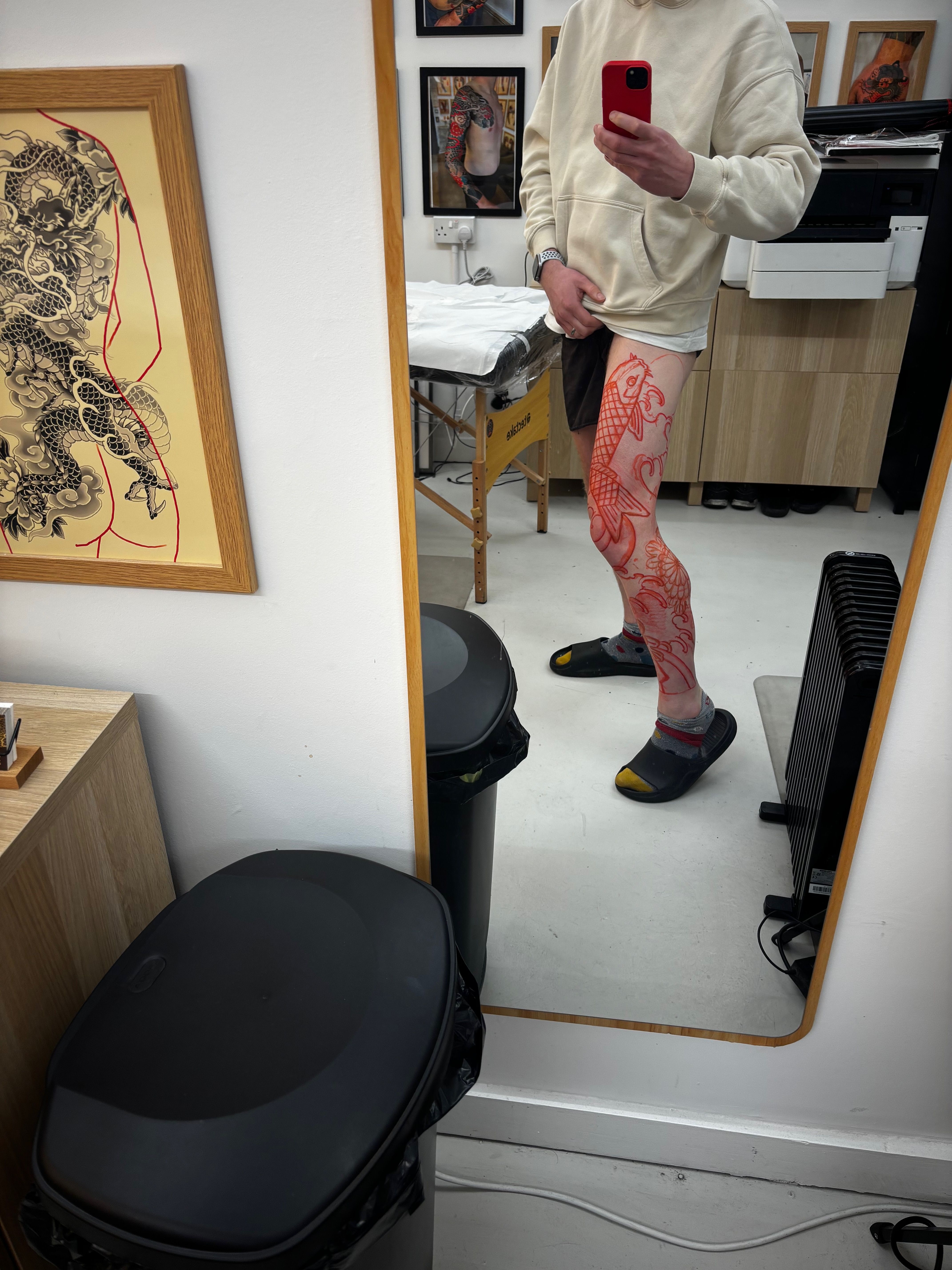 Studio mirror selfie with the koi and chrysanthemum stencil freshly drawn onto the right leg in red