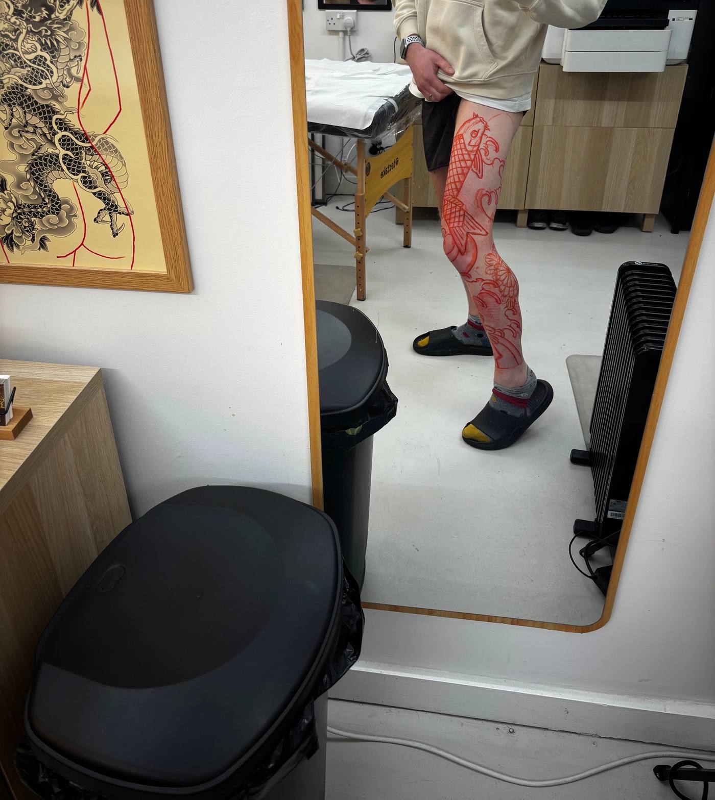 Studio mirror selfie with the koi and chrysanthemum stencil freshly drawn onto the right leg in red