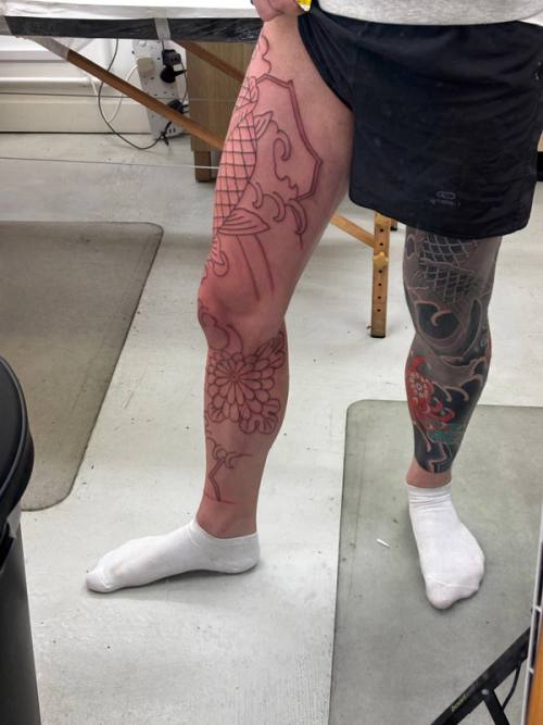 Outlined koi and chrysanthemum on the left leg, seen from the side