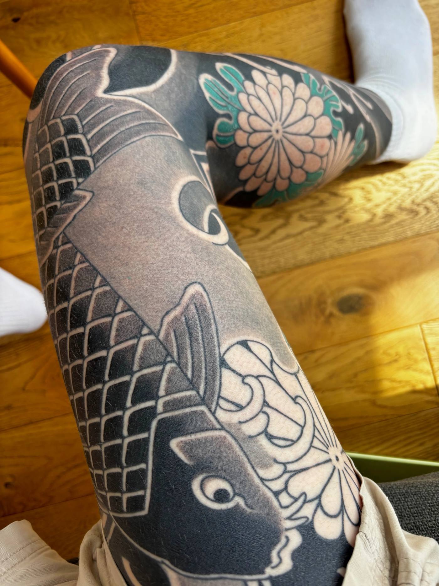 Looking down the healed right thigh: the shaded koi, with green now in the chrysanthemum petals at the knee