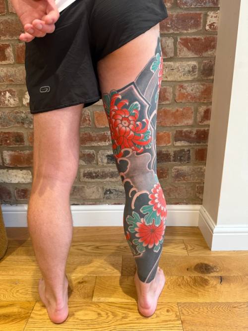 Back of the finished right leg: the chrysanthemum on the rock at the thigh, and the flowers on the calf now red
