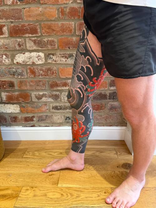 The finished right leg from the side, red flowers against the black background