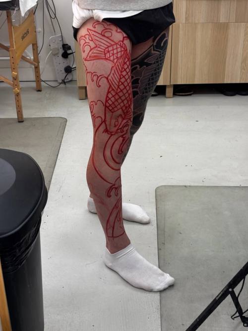 Side view of the left leg stencil: the koi on the thigh, waves down the calf