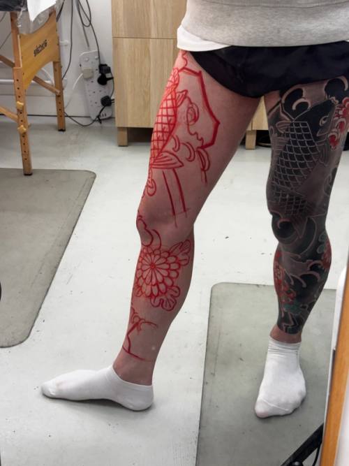 Outside of the left leg with the koi head and a chrysanthemum drawn in red
