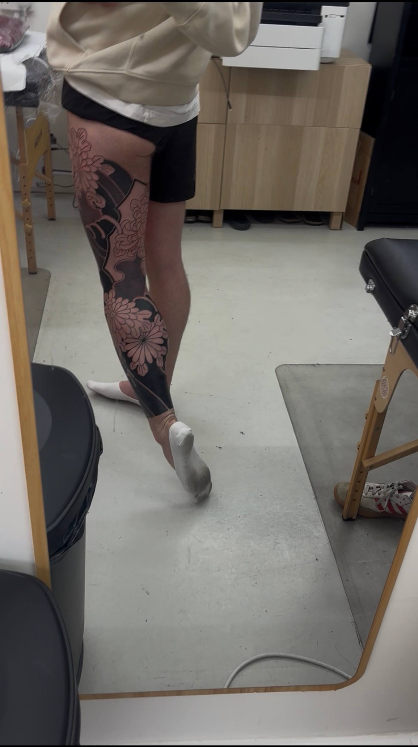 Right leg in the studio mirror at the end of the back-to-back, background shaded from the knee down