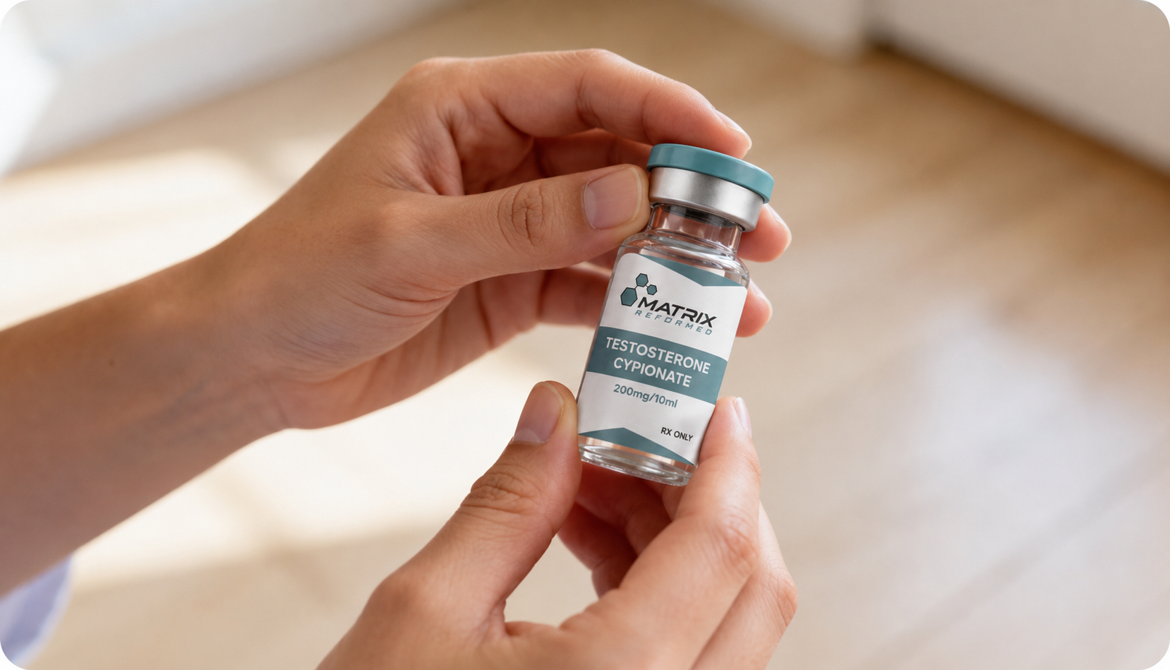 Hands holding a testosterone cypionate vial used for testosterone replacement therapy