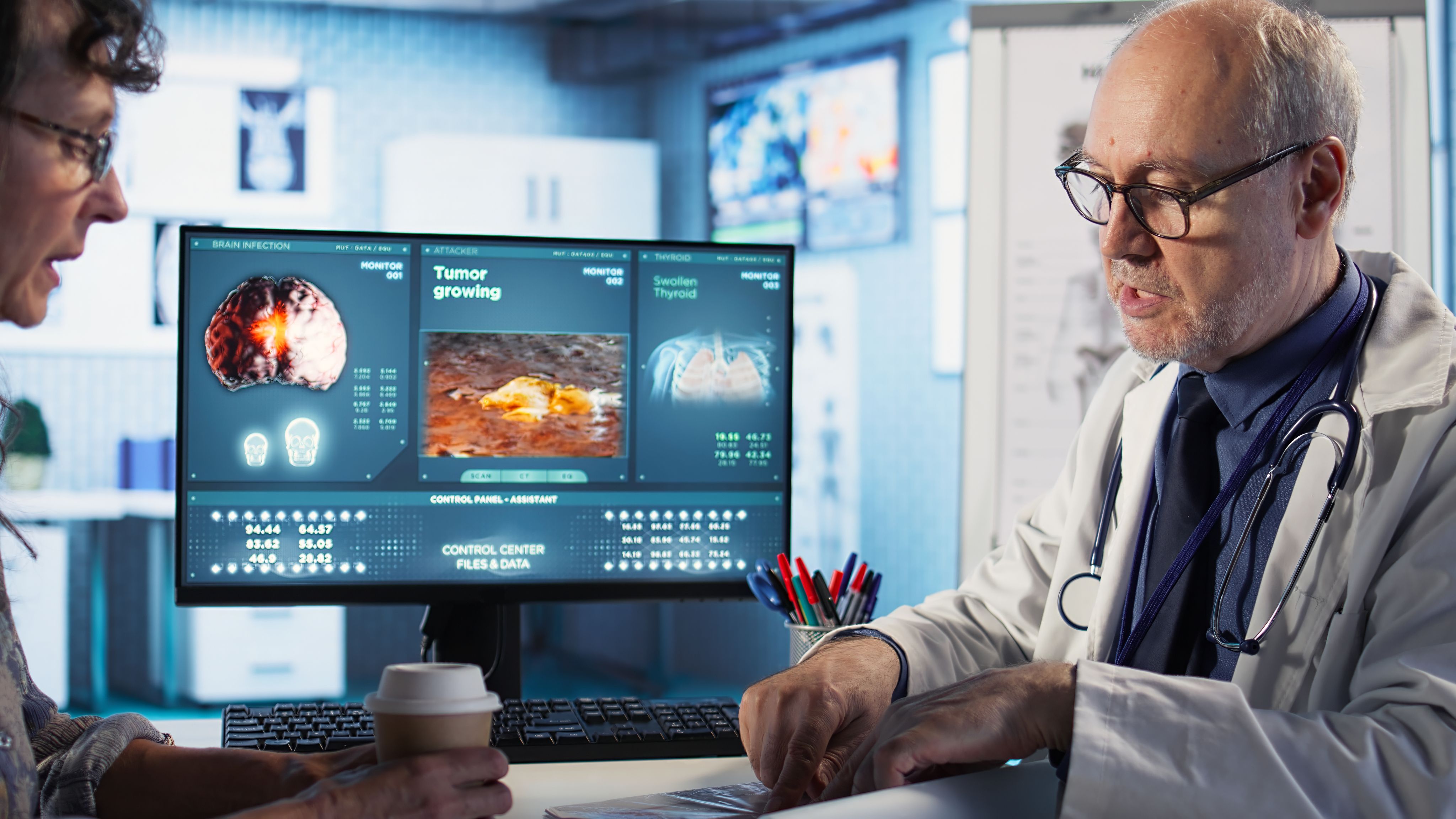 A doctor reviews medical scan results with a patient in a clinic, pointing to diagnostic images displayed on a computer monitor during a consultation.
