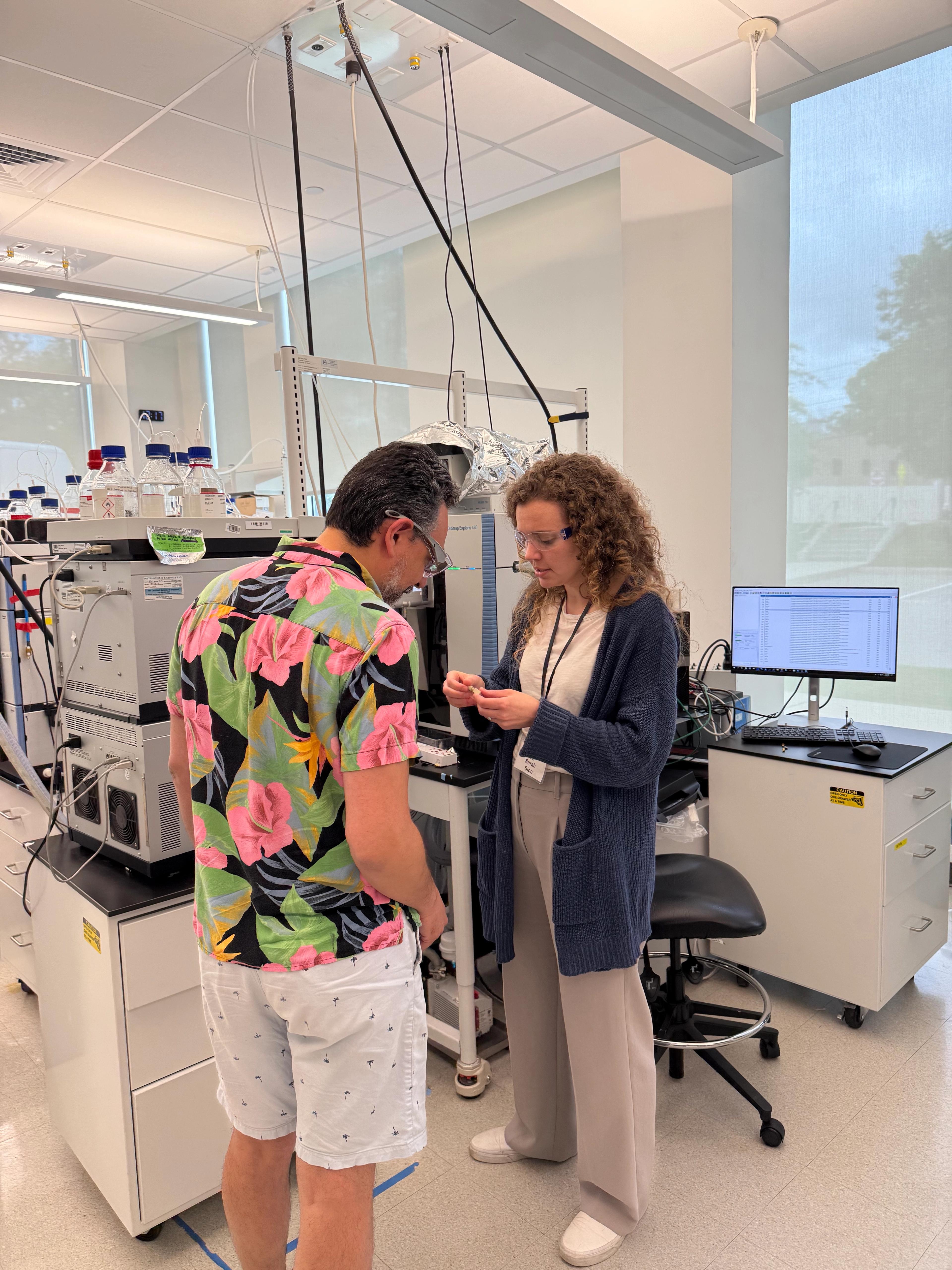 PTI's Sarah Sipe shows a workshop participant an angle blower which is used to clean the front end of a mass spectrometer.