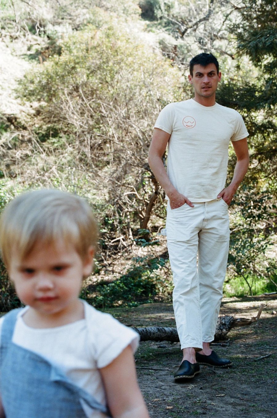 a man standing next to a little girl in a forest