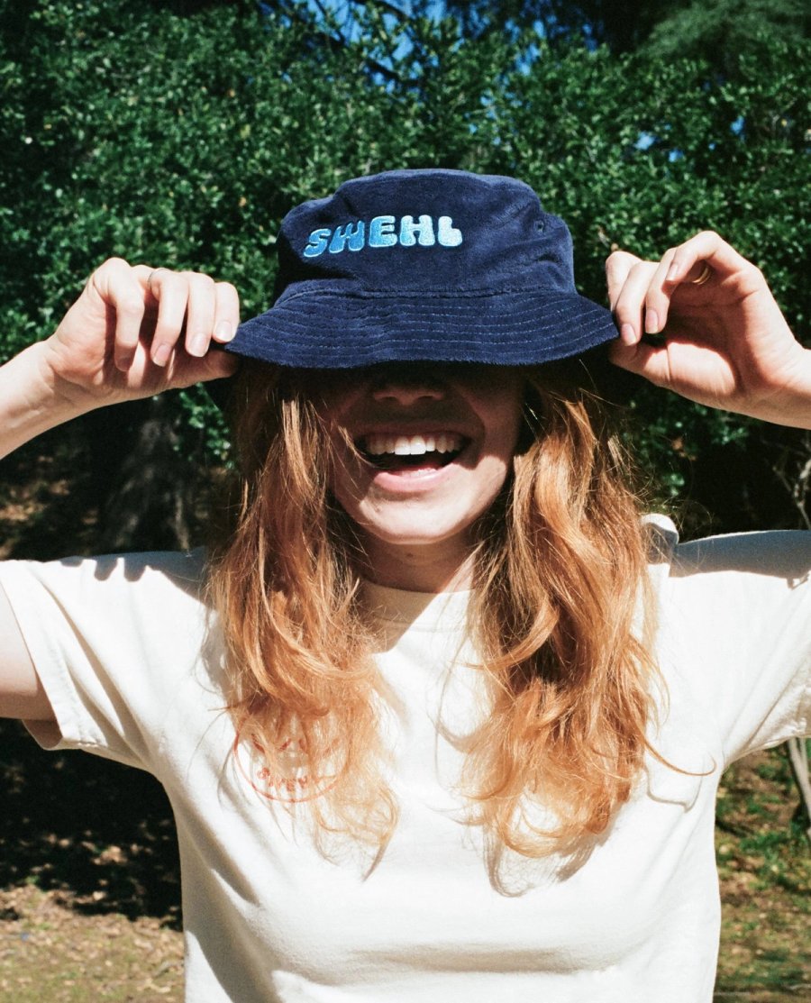 a woman wearing a hat with the word sheh on it