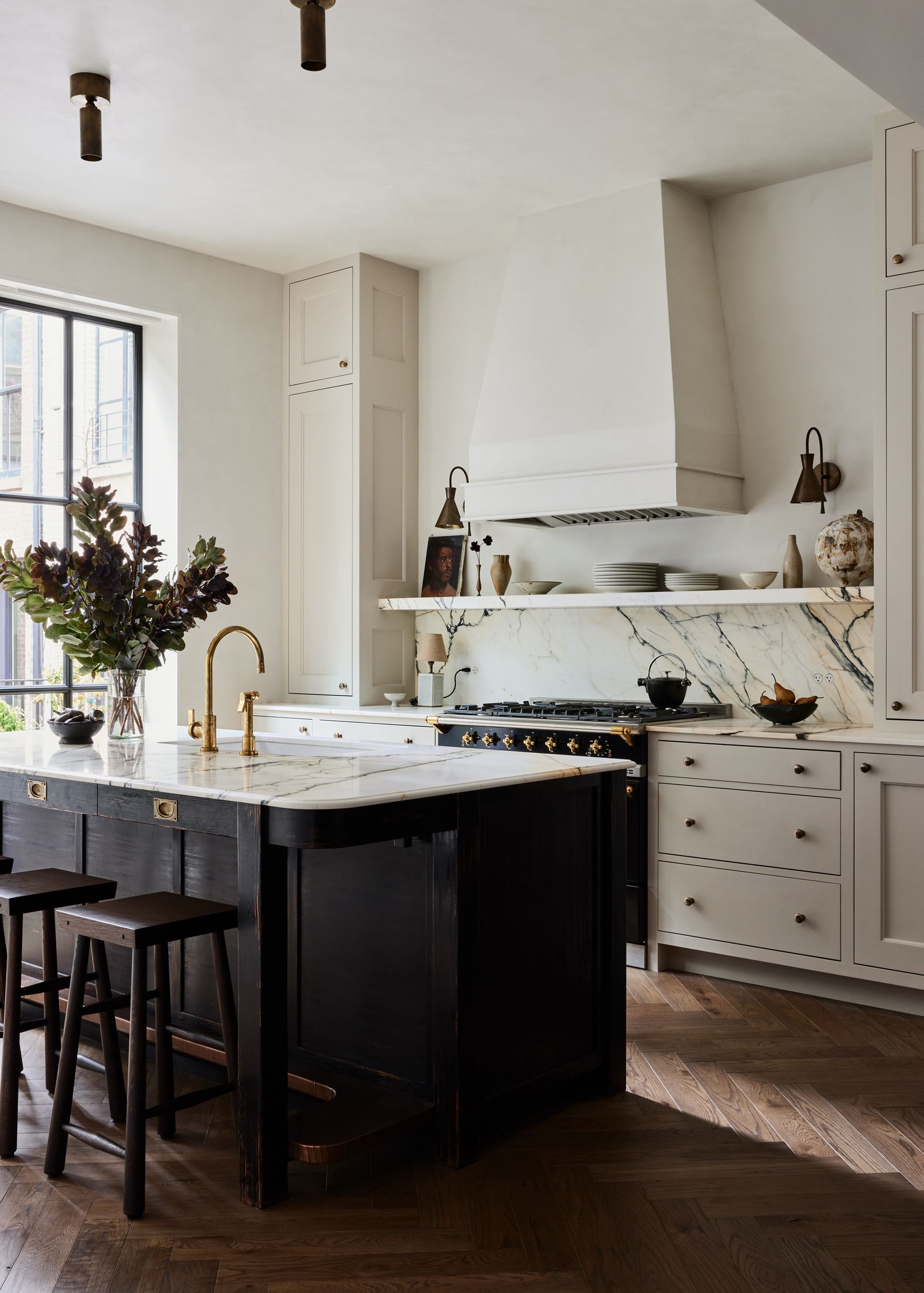 Kitchen with black oak island, high ceilings and marble counters