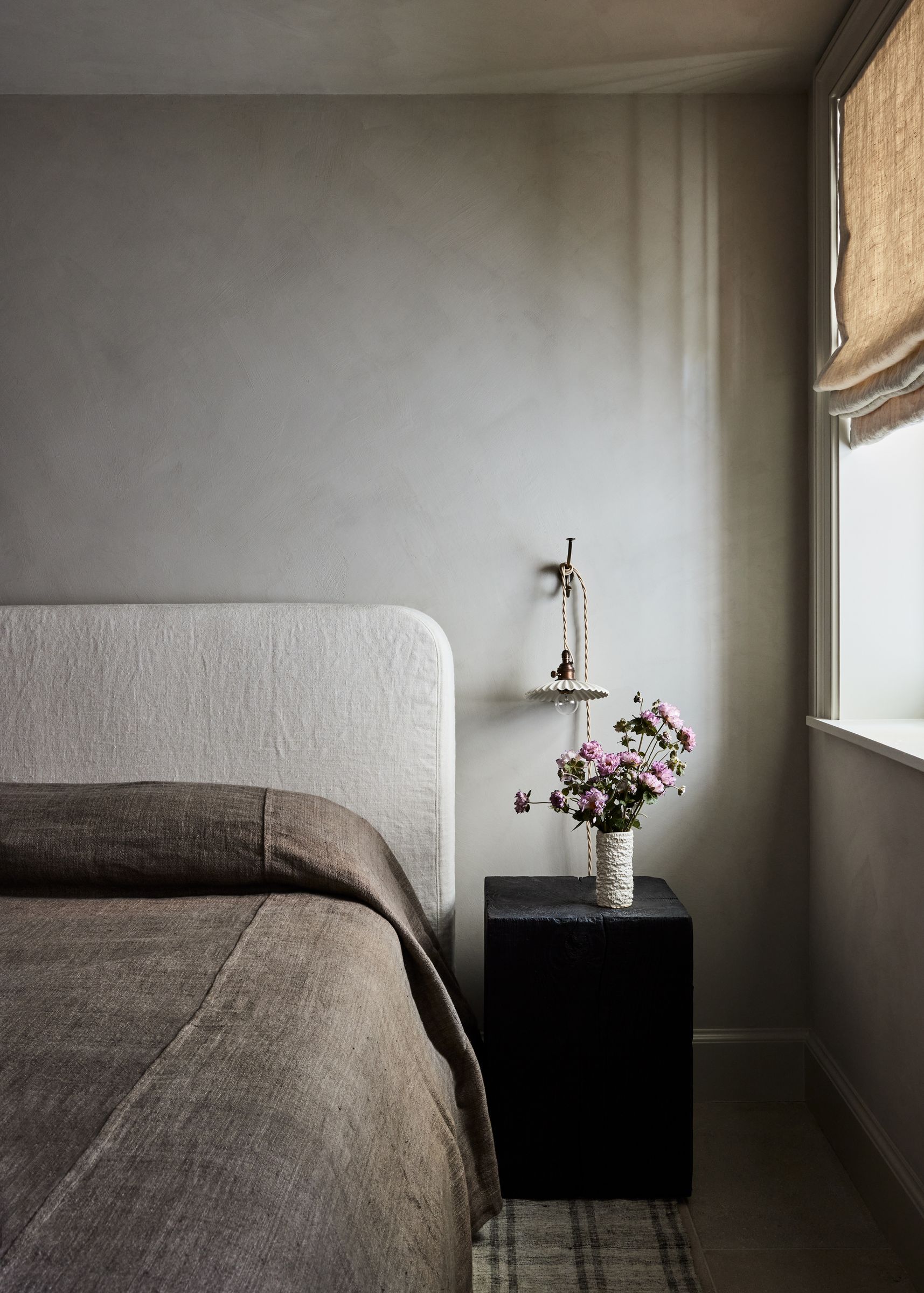 Guest Bedroom with limewash walls, white linen headboard and black nightstand
