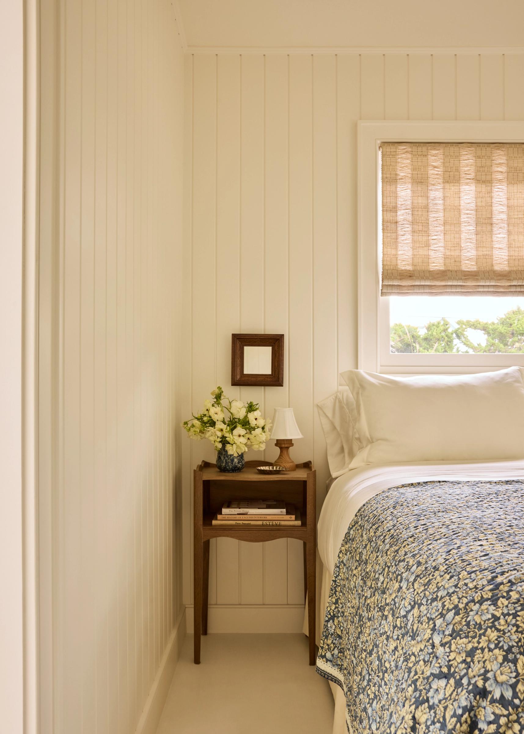 Bed with floral quilt and wood nightstand