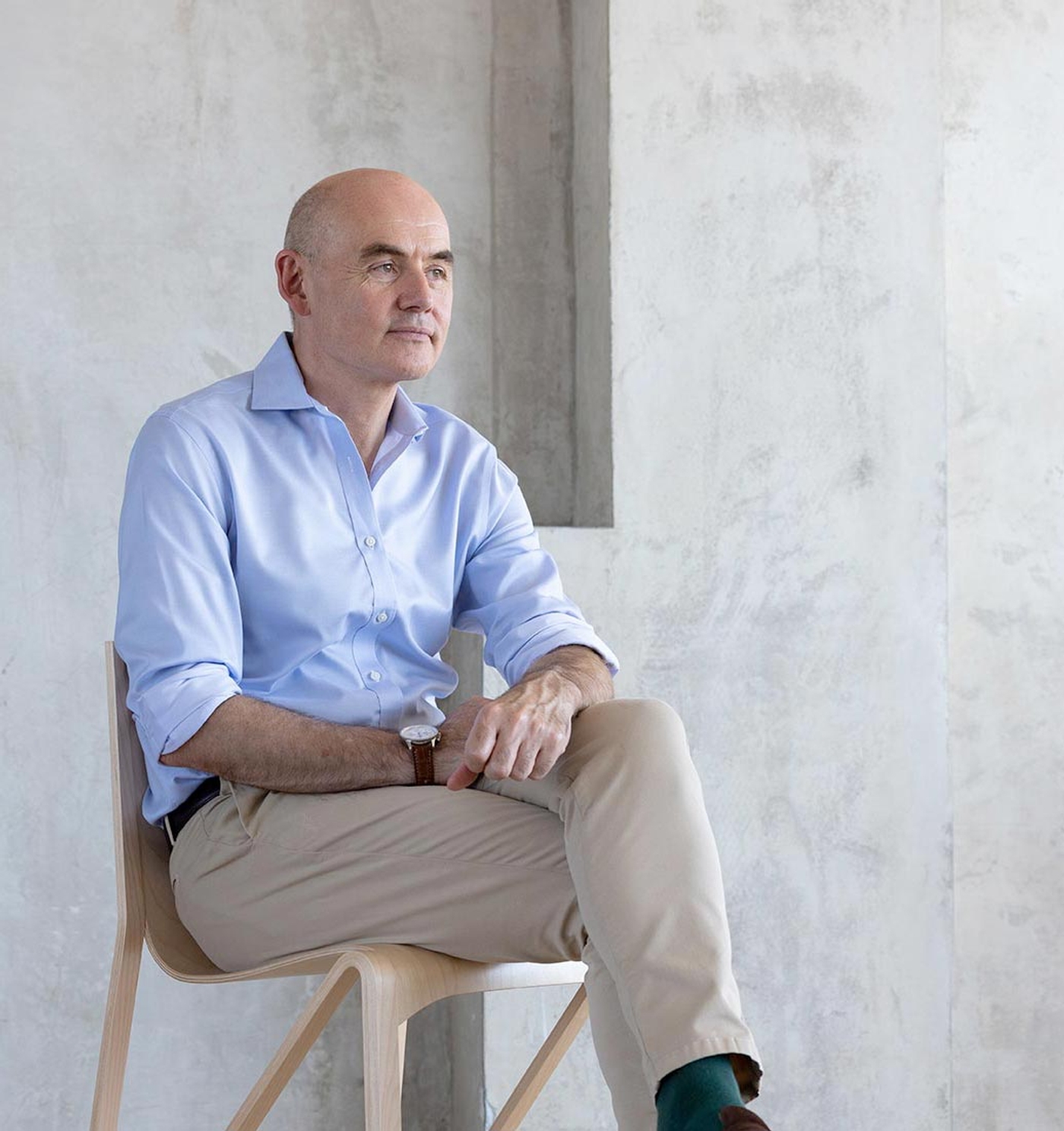 Mr Paul Harris sitting cross-legged in a chair