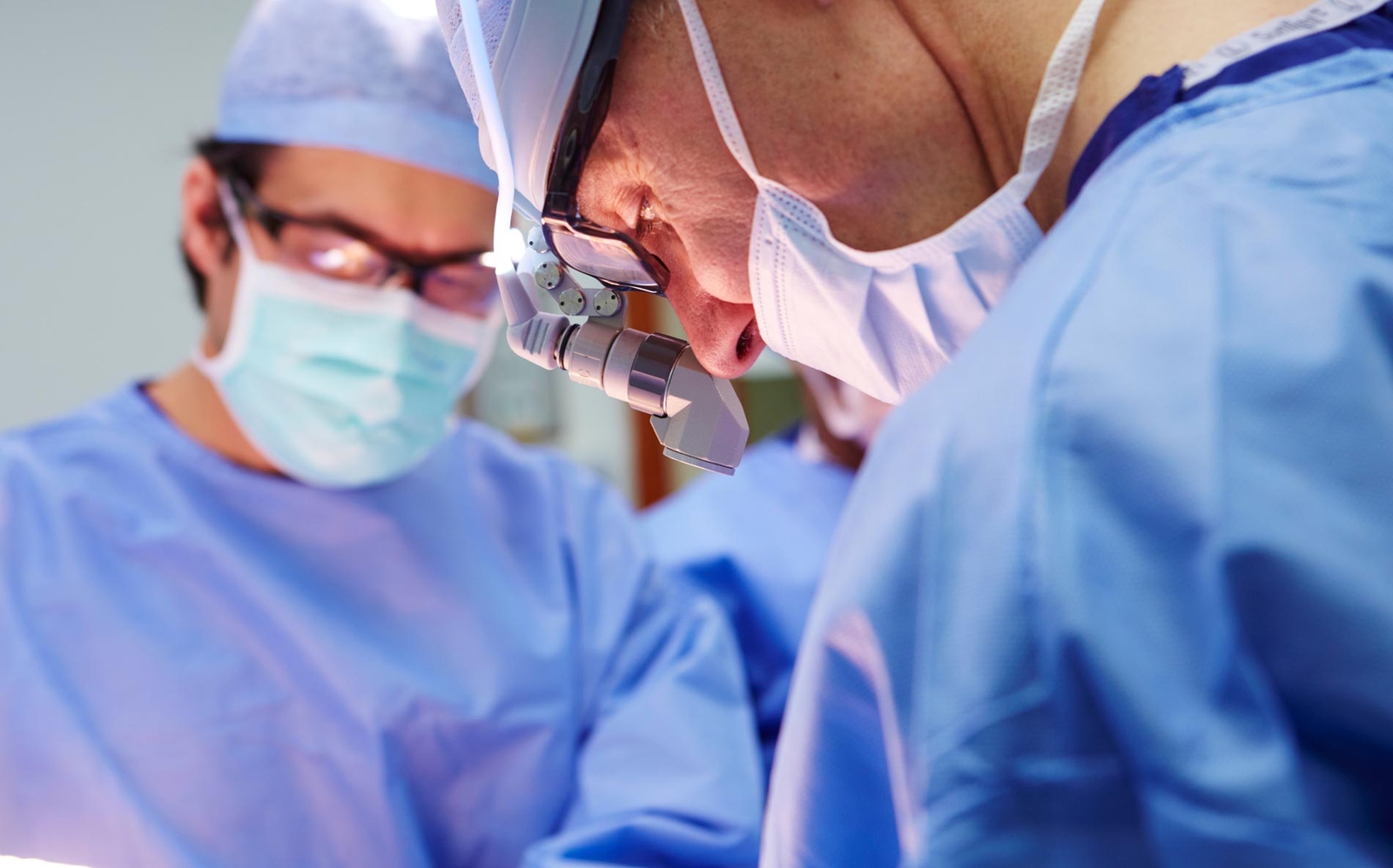 Doctors wearing scrubs in theatre during surgery
