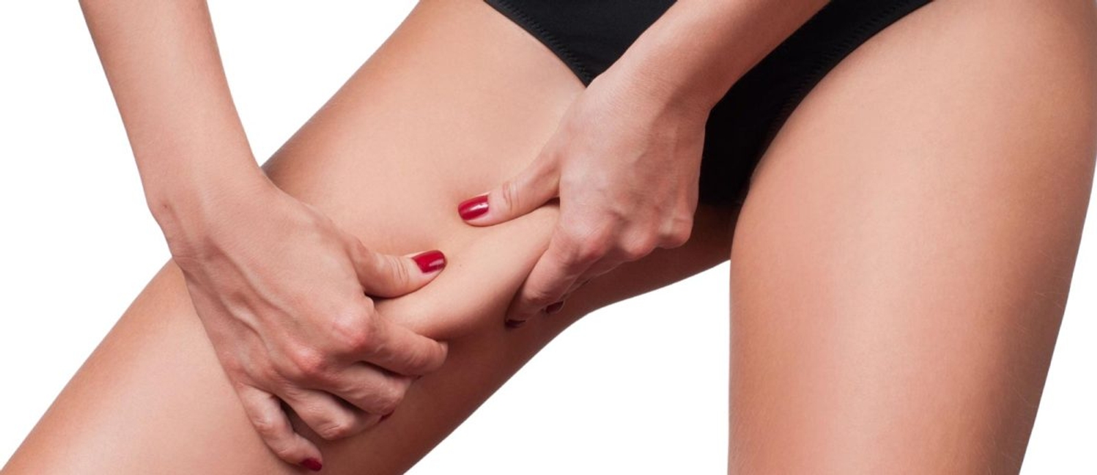 Woman gripping excess fat on her thigh