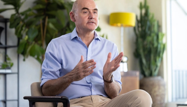 Mr Paul Harris sitting in a chair, his hands animated, explaining something