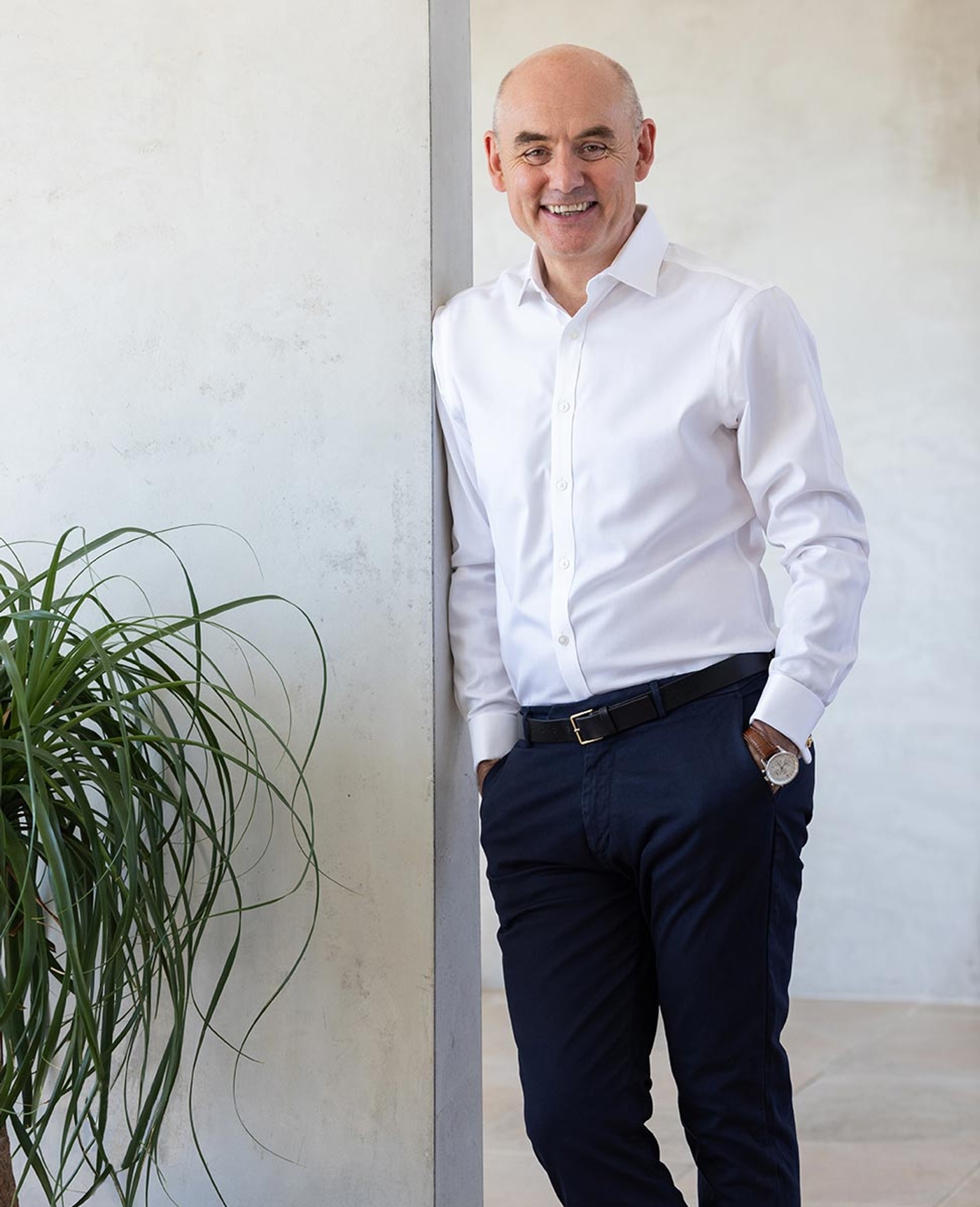 Mr Paul Harris wearing a white shirt leaning against a wall