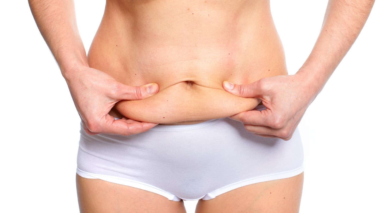Woman holding and pinching excess fat on abdomen