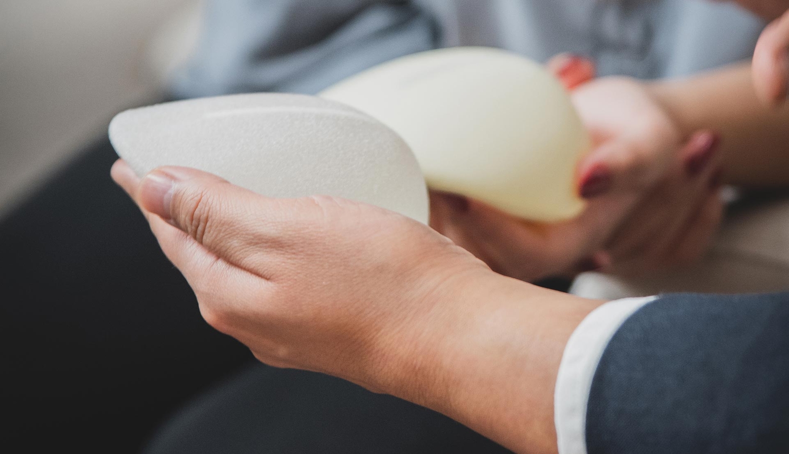 Doctor holding breast implant in his hands close up