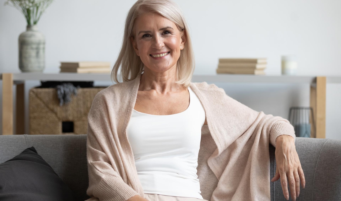 Woman sitting on sofa smiling at the camera