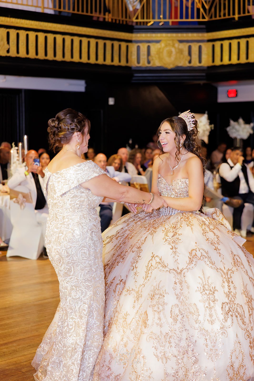 Sophia riendo mientras baila de la mano con su mamá en su quinceañera en Omaha