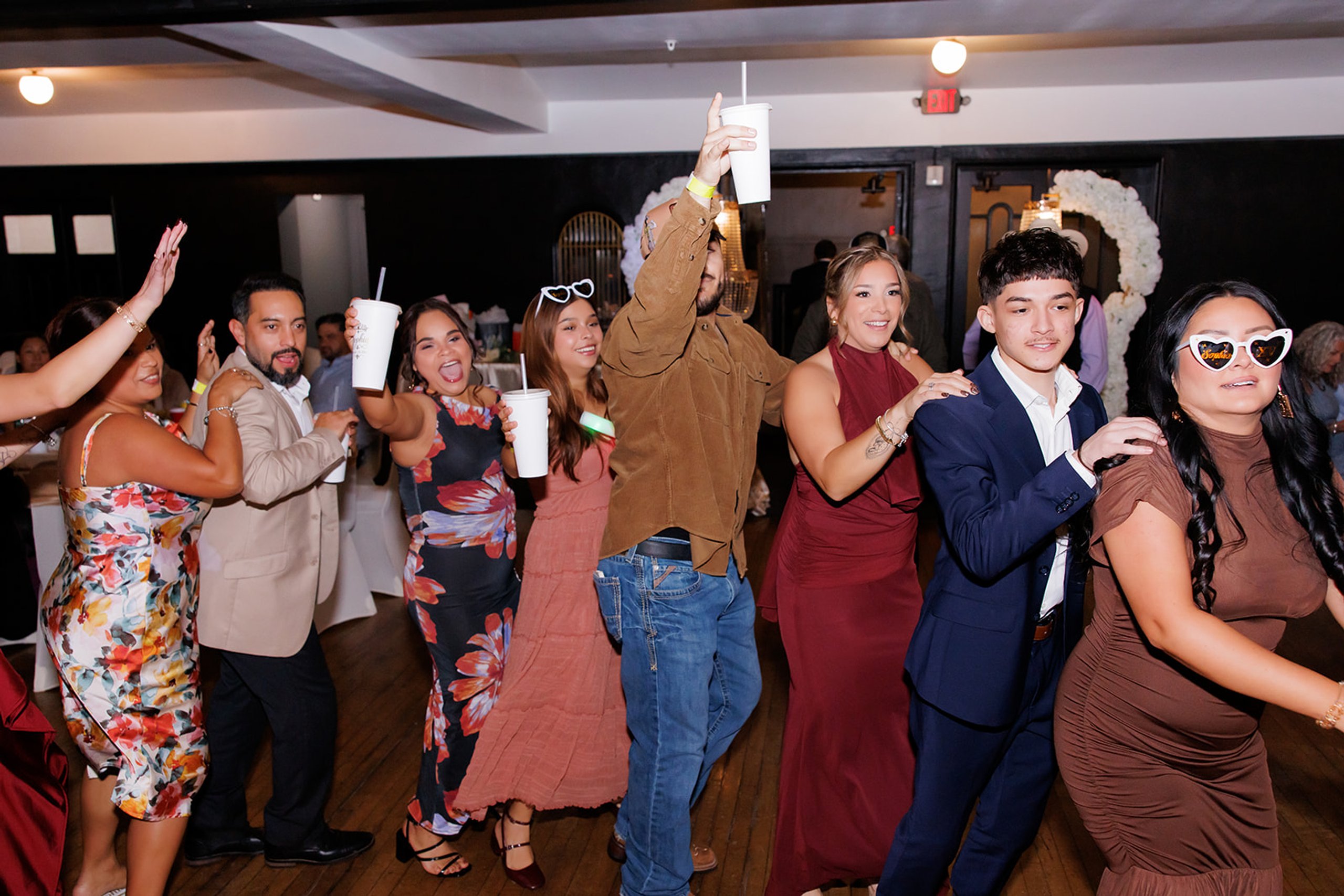Invitados bailando en trencito en la pista durante una quinceañera en Admiral Theater, Omaha