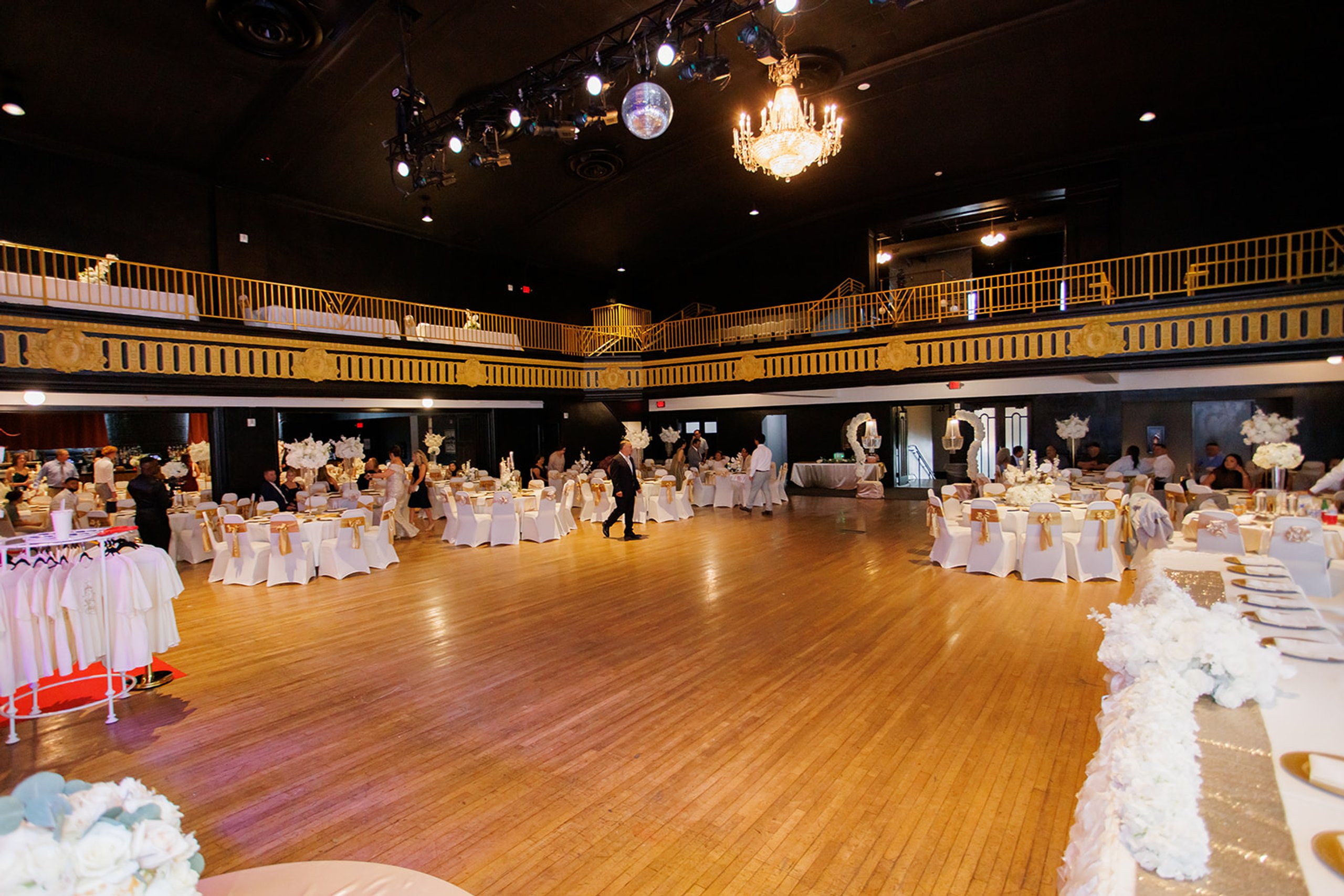 Vista amplia del salón de Admiral Theater en Omaha con mesas blancas para una quinceañera