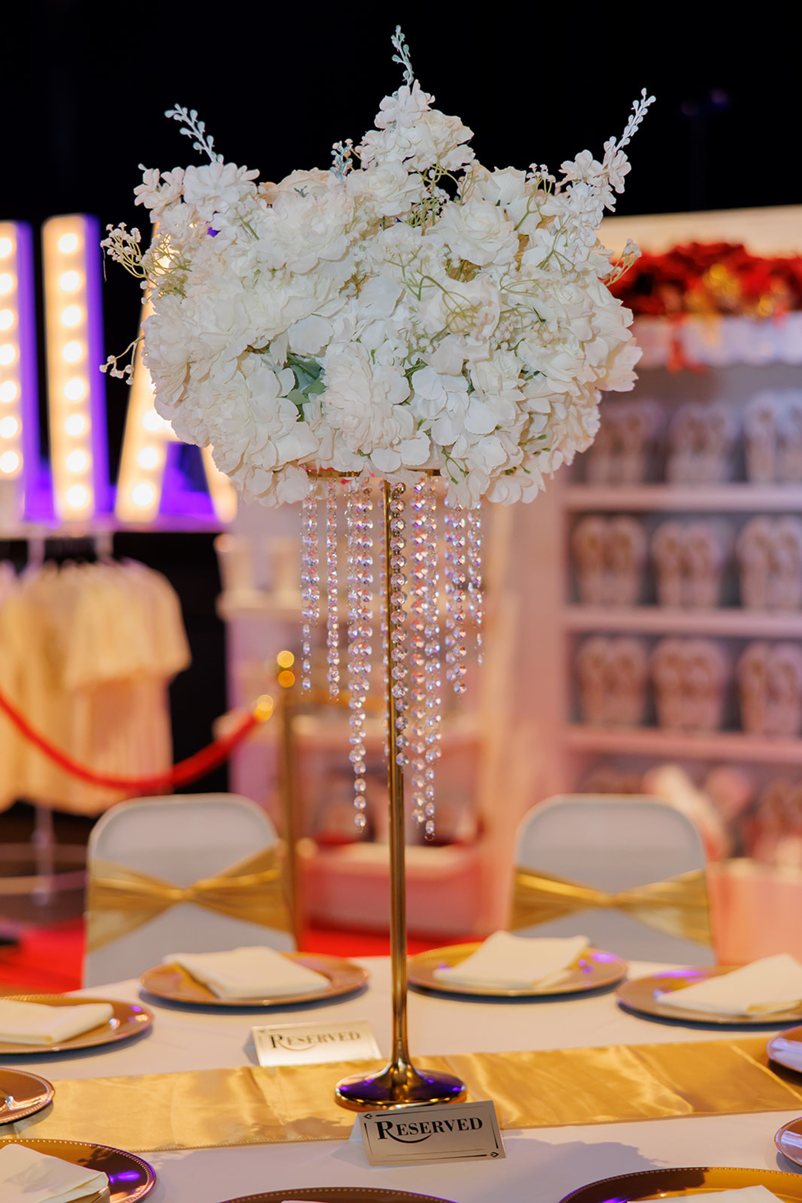 Alto centro de mesa de flores blancas con cristales colgantes en una quinceañera en Admiral Theater, Omaha