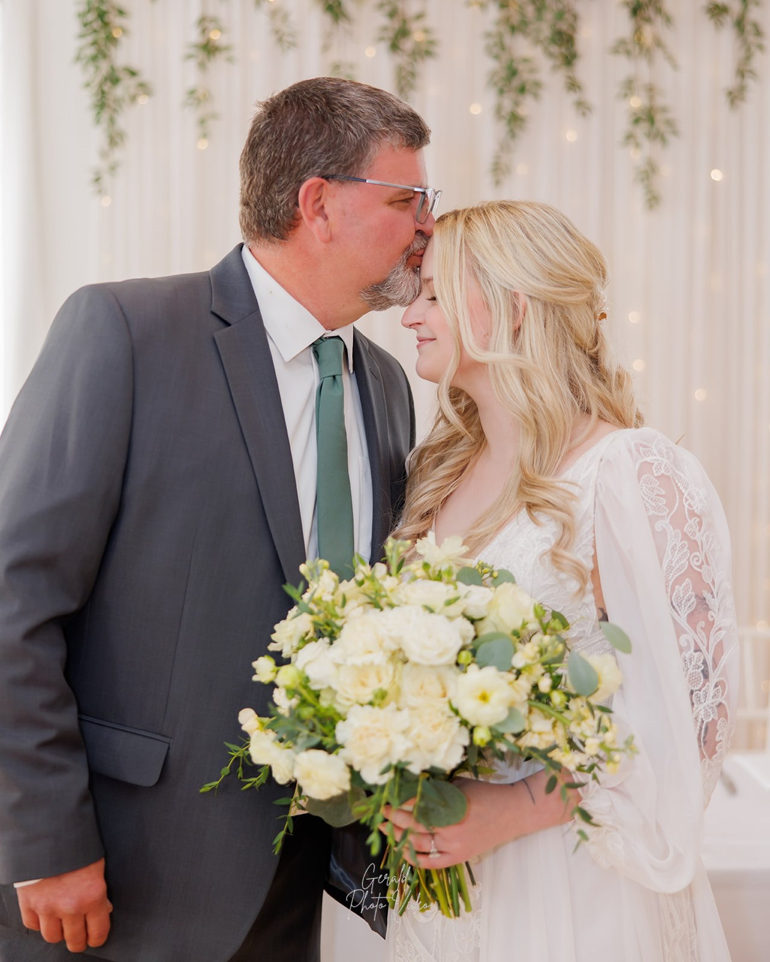 Father kissing his daughter Logan beside her bouquet before the wedding at The Arbor Event Venue, Omaha