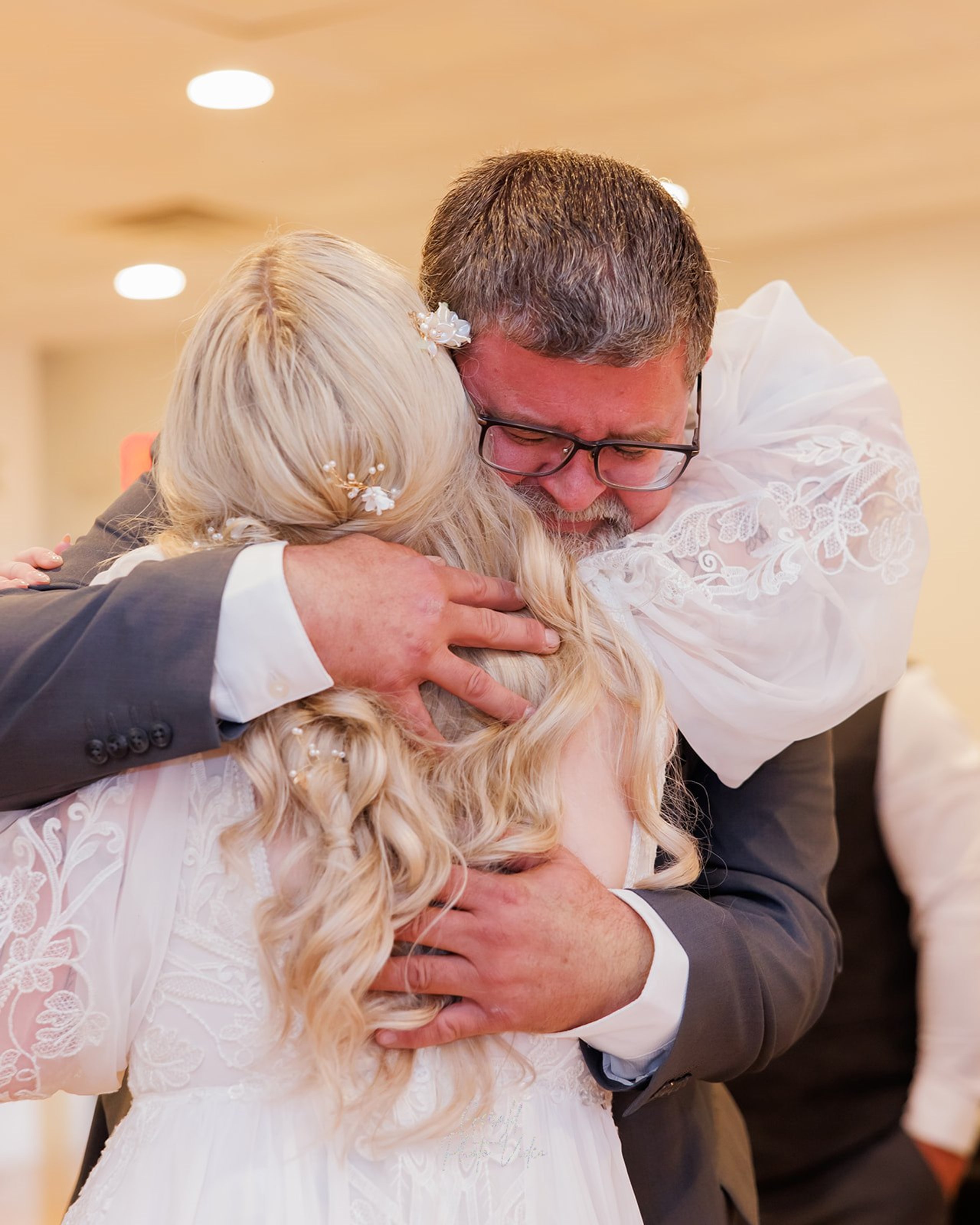 Emotional hug between a bride and her father on her wedding day in Omaha