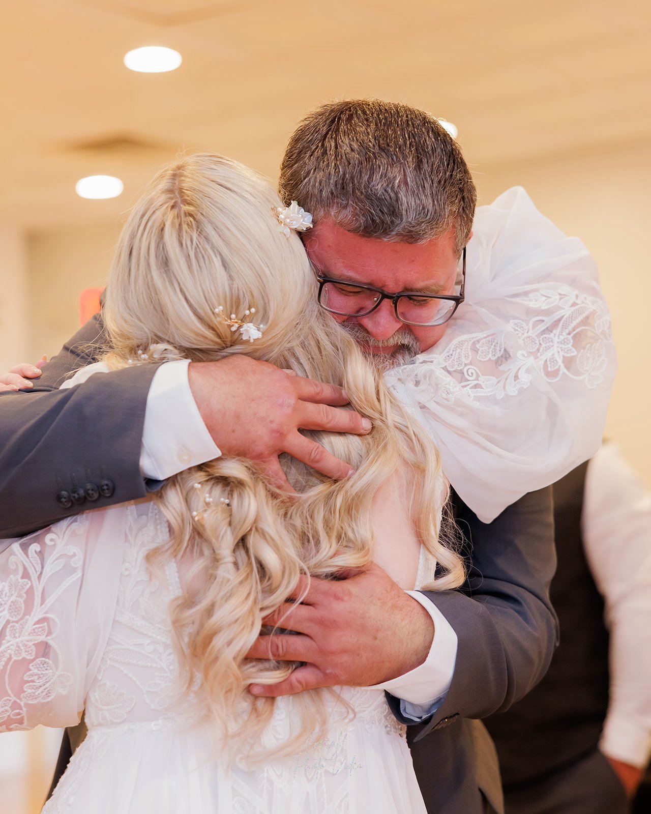 Emotional hug between a bride and her father on her wedding day in Omaha