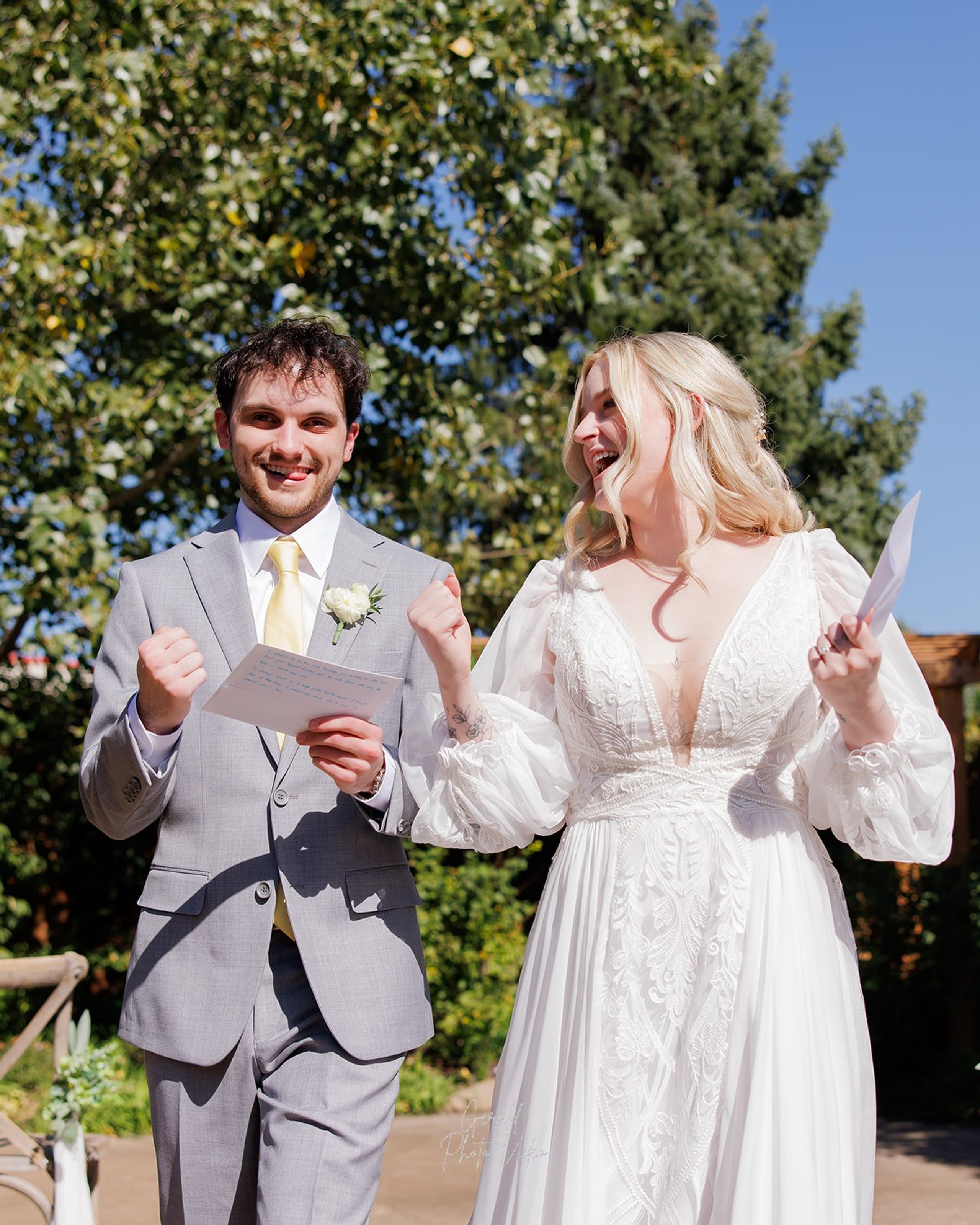 Logan and John cheering with joy after their outdoor wedding ceremony at The Arbor Event Venue in Omaha, Nebraska