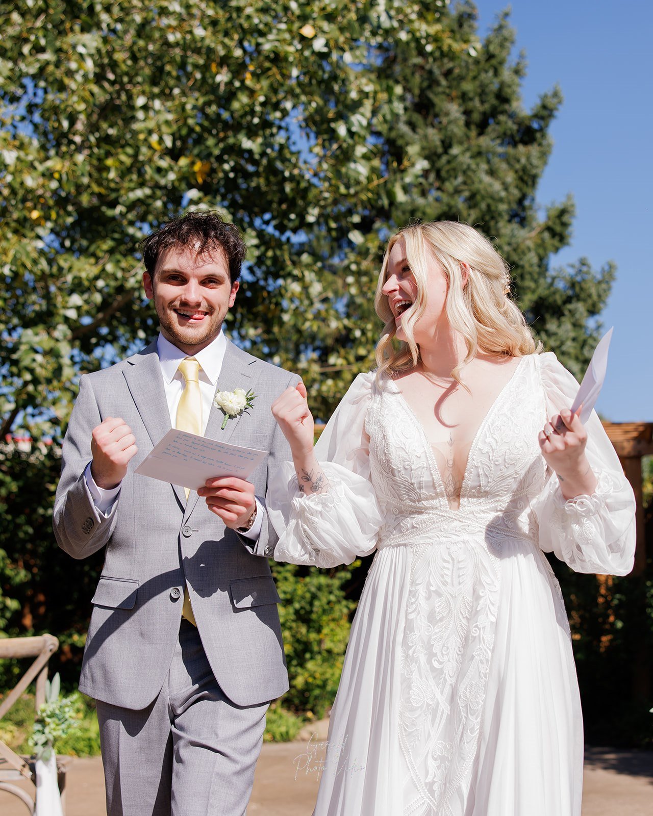 Logan and John cheering with joy after their outdoor wedding ceremony at The Arbor Event Venue in Omaha, Nebraska