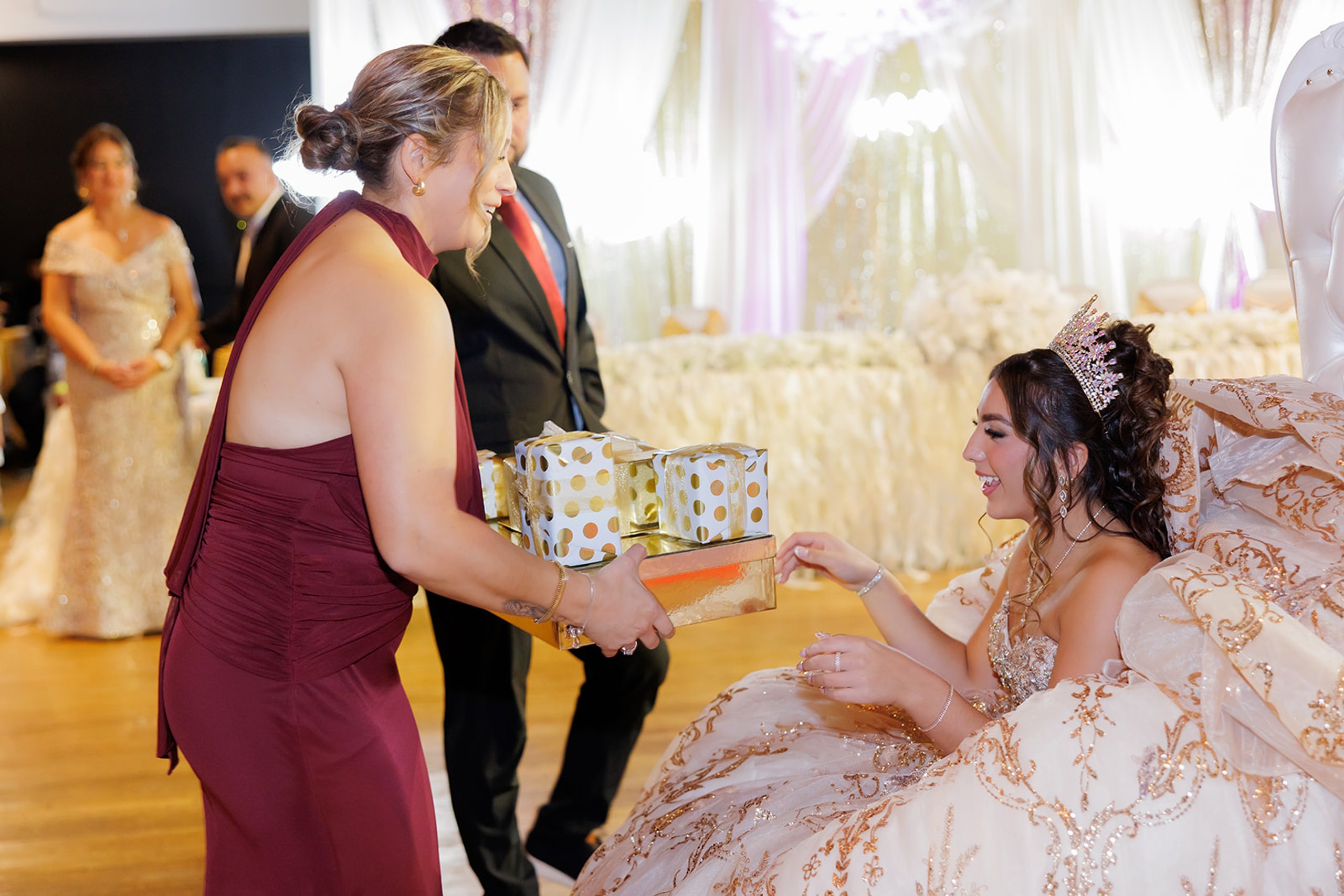 Una invitada entregando regalos envueltos a Sophia durante su quinceañera en Admiral Theater, Omaha